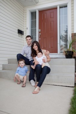 Family Portrait Sitting In Front Of Their House clipart