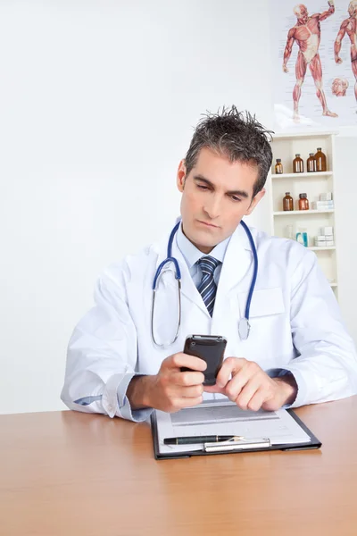 Мужской врач с помощью мобильного телефона — стоковое фото