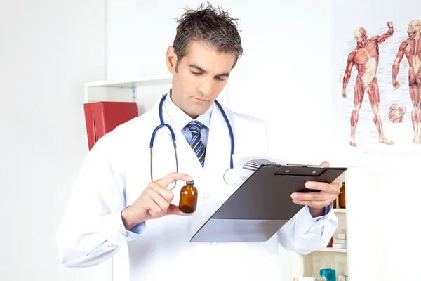 Médico segurando prancheta e garrafa — Fotografia de Stock