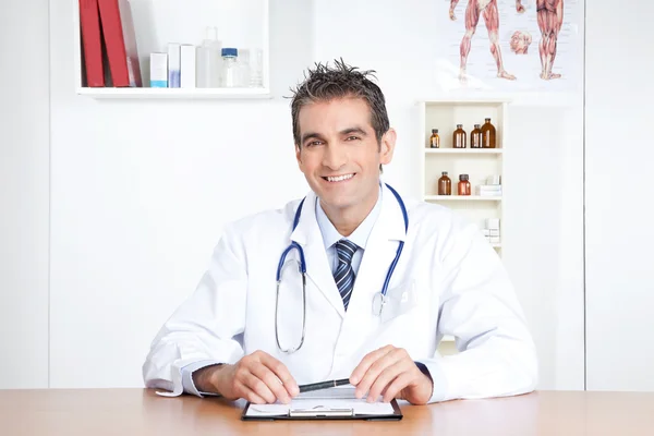 Manliga läkare sitter vid skrivbord Stockfoto