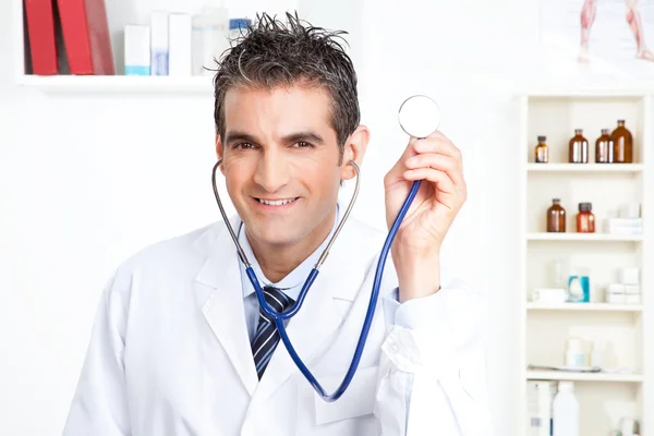 Médico masculino segurando estetoscópio Imagens Royalty-Free