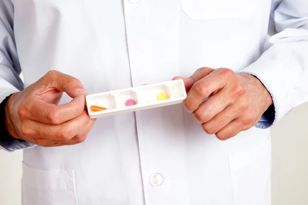 Masculino médico mão segurando pílulas — Fotografia de Stock