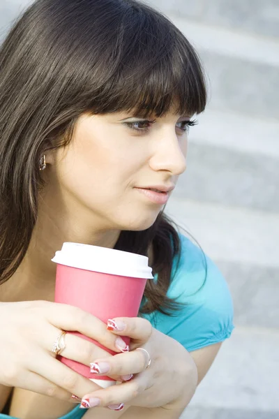 Kvinna i en park som dricker kaffe — Stockfoto