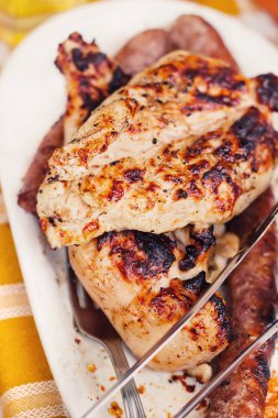 marine edilmiş ızgara tavuk biftek ve bir tabak sosis