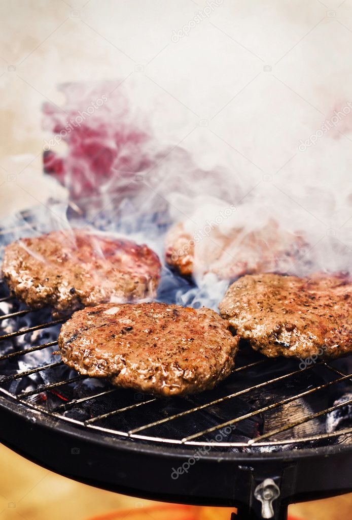 Burger patties on a grill Stock Photo by ©anatema 10215115