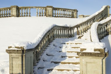 A snow-bound stone stair is in a winter park clipart