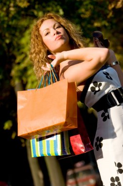 Attractive red-haired woman with shopping bags clipart