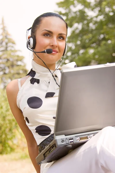휴대용 퍼스널 컴퓨터와 헤드셋 아름 다운 여자 — 스톡 사진