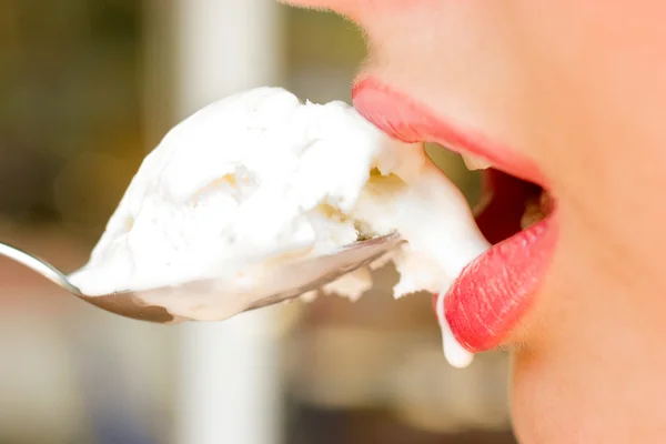 Крупный план красивых женских губ с мороженым в ложке — стоковое фото