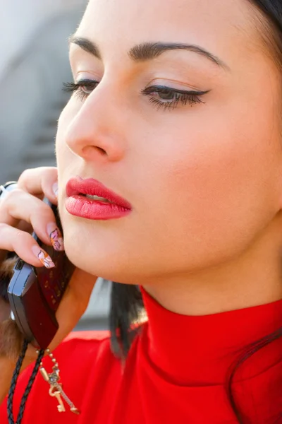 Hinreißende emotionale Brünette trägt rotes Kleid mit Handy — Stockfoto