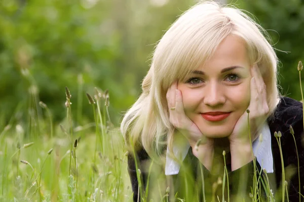 Glückliches blondes Model über dem grünen Gras — Stockfoto