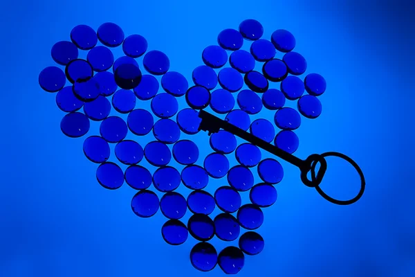 Kształt serca szklane kamyki z klucza wewnątrz — Zdjęcie stockowe