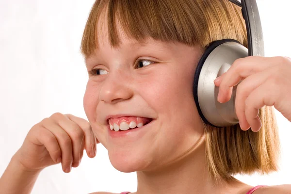 Vacker leende liten flicka med hörlurar isolerad på vit — Stockfoto