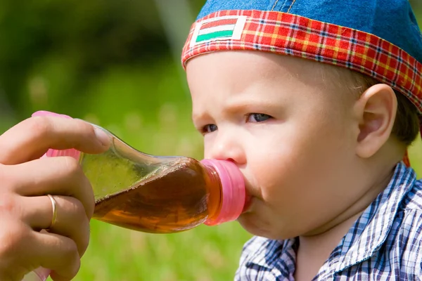 Menino bonito bebendo de garrafa de plástico — Fotografia de Stock