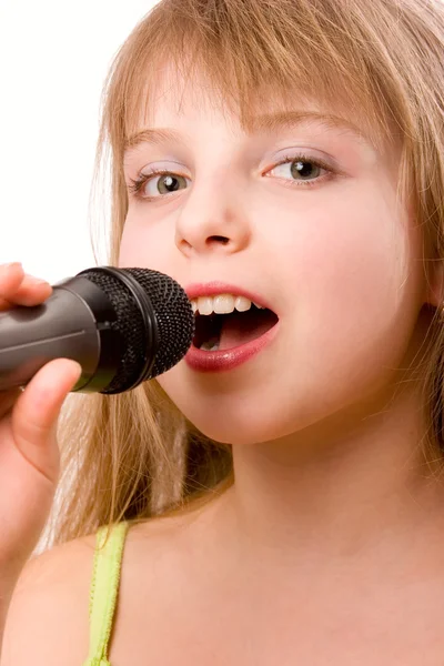 Bastante niña cantando en micrófono aislado sobre blanco —  Fotos de Stock