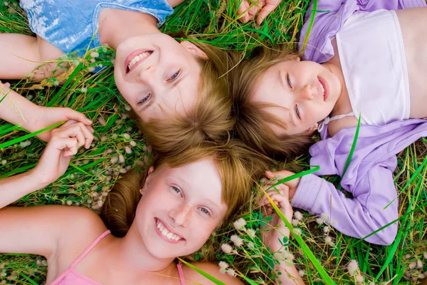 Güzel çocuk ve genç kızlar yeşil çimenlerin üzerinde — Stok fotoğraf