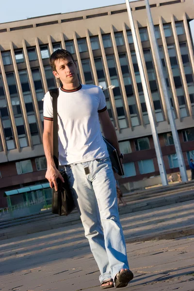 stock image Man with laptop walking along street