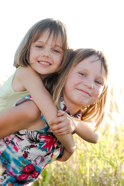 Ευτυχισμένος μικρότερες αδελφές στο καλοκαίρι πράσινο λιβάδι — Φωτογραφία Αρχείου
