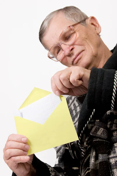 Пожилой человек открывает конверт с письмом — стоковое фото