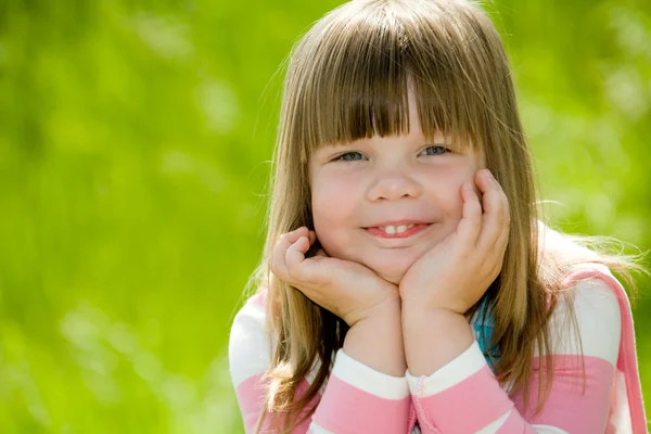 Yeşil Yaz çim üzerinde pembe bluz giyen küçük kız — Stok fotoğraf