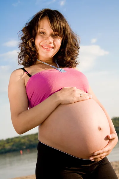 Vacker ung gravid kvinna på sommaren beach — Stockfoto