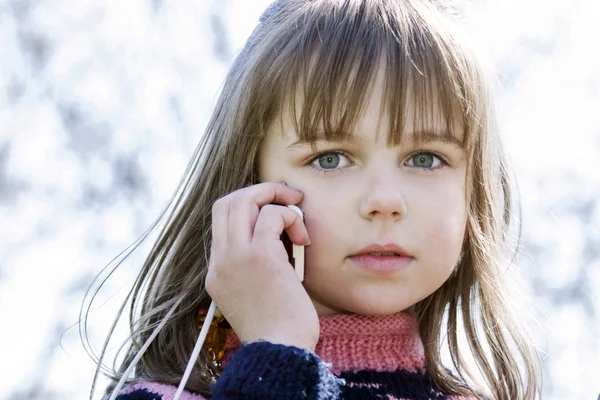 Bedårande liten flicka talar av mobiltelefon — Stockfoto