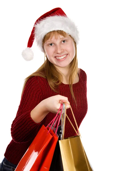 Tiener meisje in kerstmuts met shopping tassen — Stockfoto