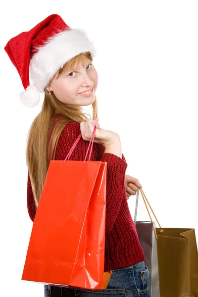 Tiener meisje in kerstmuts met shopping tassen — Stockfoto