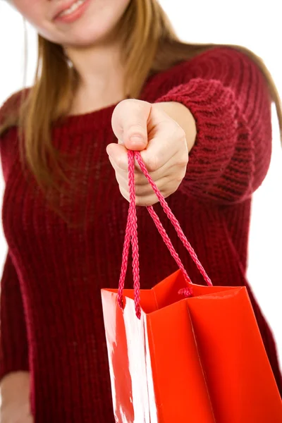 Kırmızı alışveriş çantası tutan genç kız gülümseyerek — Stok fotoğraf
