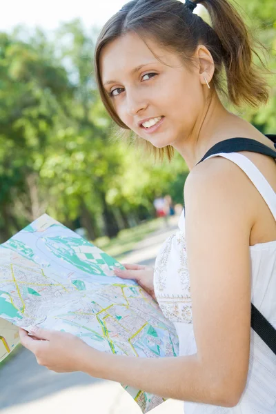 Молодая девушка держит карту города — стоковое фото