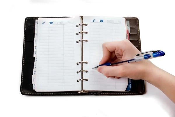 Hand skriva i öppna anteckningsbok — Stockfoto
