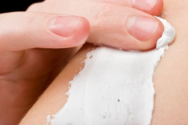 Kobiece palce zatarcia kosmetyk krem — Zdjęcie stockowe
