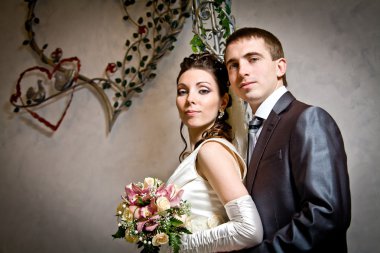 Beautiful young bride and groom in indoor setting clipart