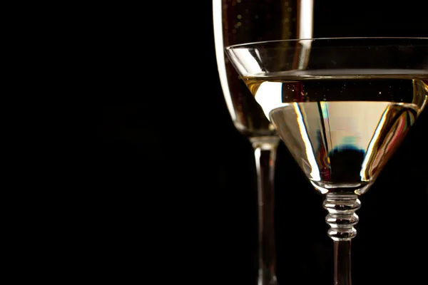Copos de champanhe e martini sobre preto — Fotografia de Stock