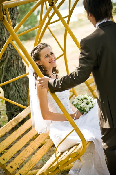 Bruidegom rockende bruid op schommel — Stockfoto