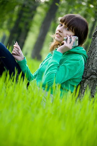 Молодая девушка из колледжа пользуется мобильным телефоном — стоковое фото