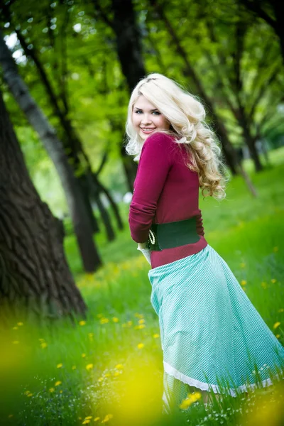 Χαμογελά ξανθιά κοπέλα πάνω από το πράσινο γρασίδι — Φωτογραφία Αρχείου