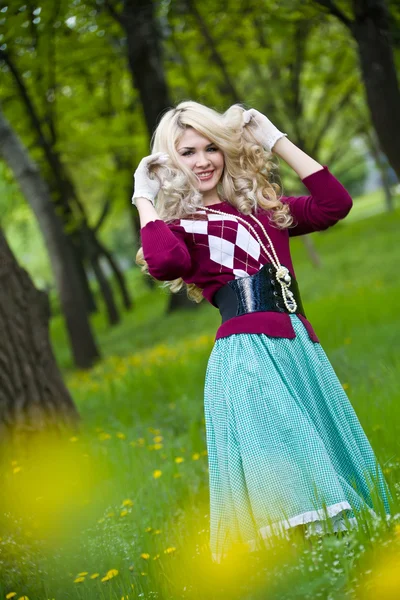 Lächeln blondes Mädchen über grünem Gras — Stockfoto