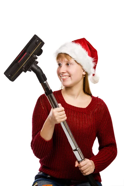 Elektrikli süpürge süpürge ile santa şapka içinde gülümseyen genç kız