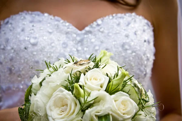 Sposa tenendo mazzo di fiori con fedi nuziali — Foto Stock