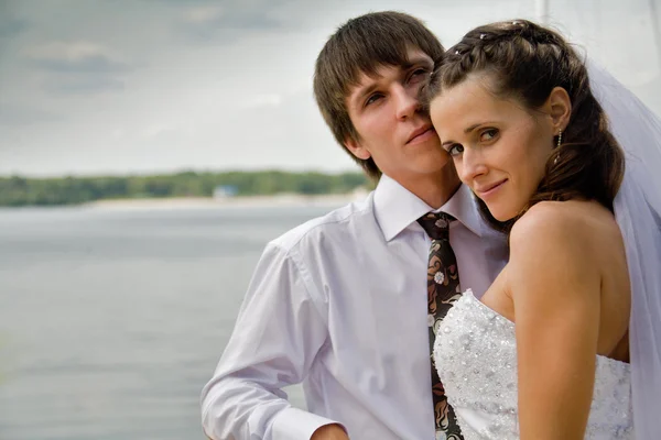 Oblubienica i pan młody obejmujący — Zdjęcie stockowe