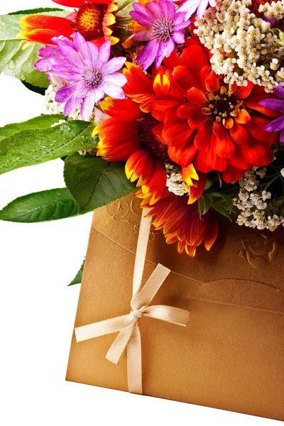 Flowers and golden colored envelope — Stock Photo, Image