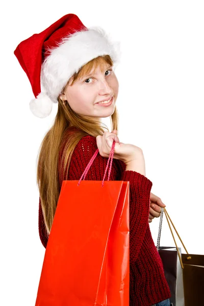 Genç kız alışveriş torbaları ile Noel şapka — Stok fotoğraf