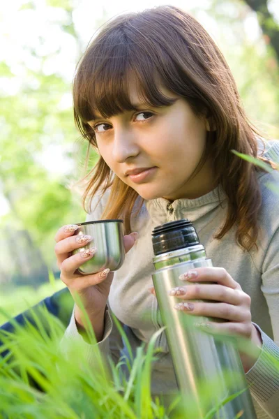 Menina adolescente bonita bebendo chá de garrafa térmica — Fotografia de Stock