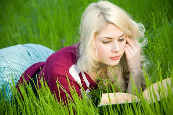 Vacker ung blond med bok i sommar park — Stockfoto