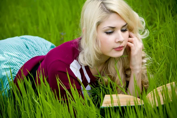 Schöne junge Blondine mit Buch im Sommerpark — Stockfoto