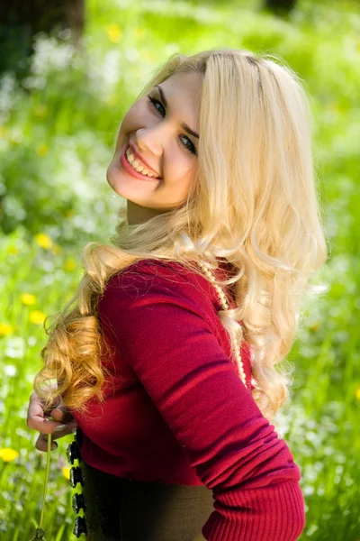 Uśmiechnięta dziewczyna blond na zielonej trawie — Zdjęcie stockowe