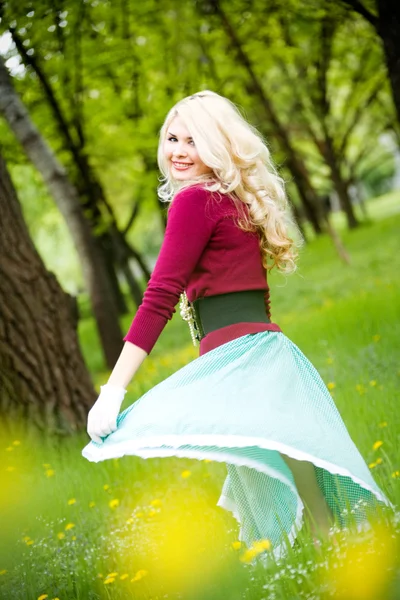 Beautiful young blond wearing long skirt in summer park — Stock Photo, Image