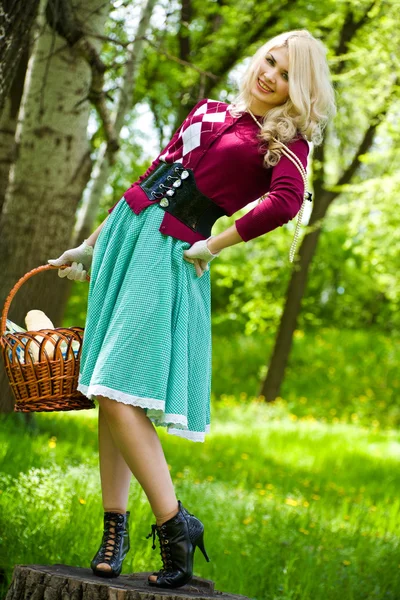 Beautiful young blond with basket in summer park — Stock Photo, Image