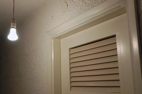 Lampa och dörr i mörka källare — Stockfoto